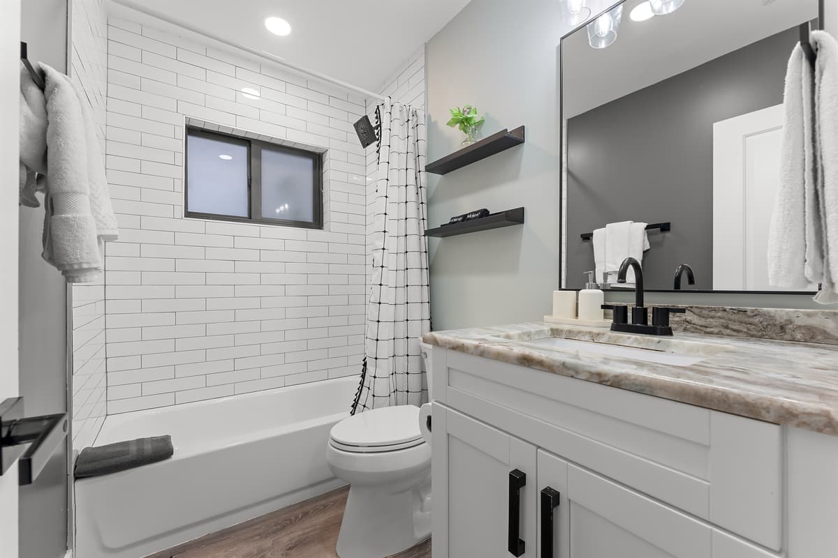 🪼 Clean and convenient — shared bath for the downstairs Queen and Bunk bed rooms with tub/shower combo and modern flair.